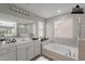Bright bathroom features a soaking tub, double vanity, and a large mirror at 316 N 78Th Pl, Mesa, AZ 85207