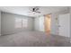 Spacious bedroom featuring neutral walls, ceiling fan, sliding barn door, and plush carpeting at 316 N 78Th Pl, Mesa, AZ 85207