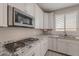 Close-up of kitchen counters, stove, and sink, showcasing granite countertops and modern appliances at 316 N 78Th Pl, Mesa, AZ 85207
