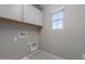 A functional laundry room space featuring storage cabinets and a window for light at 316 N 78Th Pl, Mesa, AZ 85207