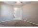 A neutral-toned living room boasts plush carpeting and an open doorway leading to the home's staircase at 316 N 78Th Pl, Mesa, AZ 85207