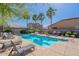 Community swimming pool featuring lounge chairs, palm trees, and well-maintained landscaping at 316 N 78Th Pl, Mesa, AZ 85207
