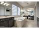 Luxurious bathroom featuring a soaking tub, dual vanities, and large windows providing ample natural light at 32819 N 23Rd Ave, Phoenix, AZ 85085