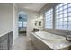 Elegant bathroom showcasing a modern soaking tub, dual sink vanity, and glass block windows for privacy and light at 32819 N 23Rd Ave, Phoenix, AZ 85085