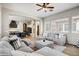 Bright living room showcasing an open layout, ceiling fan, large windows and kitchen access at 32819 N 23Rd Ave, Phoenix, AZ 85085