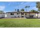 Lush backyard with a well-maintained lawn, a covered patio, an outdoor dining area, and a sturdy privacy fence at 3837 E Yale St, Phoenix, AZ 85008