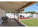 Inviting covered patio with grill area, synthetic grass, and white privacy fence at 3837 E Yale St, Phoenix, AZ 85008