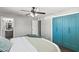 Inviting bedroom boasts hardwood floors, a ceiling fan, teal closet doors, and a view into the en-suite bathroom at 3837 E Yale St, Phoenix, AZ 85008