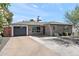Single-story home with a gray brick exterior, a dark gray garage door, and a desert landscaped front yard at 3837 E Yale St, Phoenix, AZ 85008