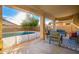 Inviting covered patio with cozy seating, outdoor rug, and view of the pool and green backyard at 4341 E Abraham Ln, Phoenix, AZ 85050