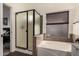 Well-lit bathroom featuring a soaking tub, frosted shower, and a neutral color palette at 43803 W Wade Dr, Maricopa, AZ 85138