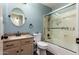 Updated bathroom with custom shower doors, a round mirror, and modern fixtures at 43803 W Wade Dr, Maricopa, AZ 85138