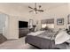 Cozy bedroom with neutral carpet, ceiling fan, large window, and furniture including desk and dresser at 43803 W Wade Dr, Maricopa, AZ 85138