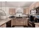 This kitchen provides black appliances and an undermount sink set into mosaic countertops at 43803 W Wade Dr, Maricopa, AZ 85138