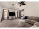 Inviting living room featuring plush carpeting, neutral colors, contemporary furnishings, and natural light at 43803 W Wade Dr, Maricopa, AZ 85138