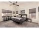 Spacious main bedroom with a ceiling fan, large windows, and comfortable carpeting at 43803 W Wade Dr, Maricopa, AZ 85138