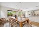 Airy dining room showcasing a large wooden table, stylish chairs, and seamless access to the outdoor patio and kitchen at 4430 E Creosote Dr, Cave Creek, AZ 85331