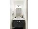 Contemporary bathroom with a black vanity, unique patterned mirror, and minimalist decor, exuding modern elegance at 5202 E Larkspur Dr, Scottsdale, AZ 85254