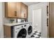 Efficient laundry room with modern washer and dryer, ample storage cabinets, and stylish black and white checkered flooring at 5202 E Larkspur Dr, Scottsdale, AZ 85254