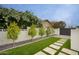 Landscaped backyard with lush greenery, walkway, and privacy wall, creating a serene outdoor space at 5441 E Wethersfield Rd, Scottsdale, AZ 85254