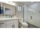 Bathroom featuring a white vanity, a black framed mirror and a modern glass-enclosed shower at 5441 E Wethersfield Rd, Scottsdale, AZ 85254