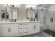 Modern bathroom showcasing double vanity sinks, sleek black fixtures, and a glass-enclosed shower at 5441 E Wethersfield Rd, Scottsdale, AZ 85254