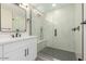 Bathroom with a modern shower, tiled walls, a glass door, and white vanity at 5441 E Wethersfield Rd, Scottsdale, AZ 85254