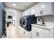 Convenient laundry room featuring a modern washer and dryer set, sink, and ample cabinet space at 5441 E Wethersfield Rd, Scottsdale, AZ 85254