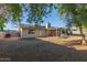 Large backyard with gravel, mature trees, solar panels, and a patio with furniture at 5529 W Villa Maria Dr, Glendale, AZ 85308