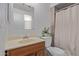 Cozy bathroom with a wood vanity, mirror, and tiled shower and bathtub at 5529 W Villa Maria Dr, Glendale, AZ 85308
