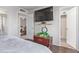 Bedroom interior with wood flooring, a mounted TV, and doorway views to the living areas at 5529 W Villa Maria Dr, Glendale, AZ 85308