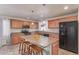 Bright kitchen features wood cabinets, an island with bar seating, and stainless steel appliances at 5529 W Villa Maria Dr, Glendale, AZ 85308
