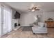 This open-concept living room features a cozy fireplace, a ceiling fan, and tile flooring at 5529 W Villa Maria Dr, Glendale, AZ 85308
