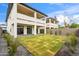 Spacious backyard offering a manicured lawn, privacy fence, and modern architectural details of the home at 5537 E Earll Dr, Phoenix, AZ 85018