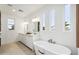 Bright bathroom featuring dual vanities, a soaking tub, and large windows providing natural light at 5537 E Earll Dr, Phoenix, AZ 85018
