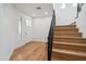 Inviting entryway featuring light wood floors, white walls, and a modern staircase with a black railing at 5537 E Earll Dr, Phoenix, AZ 85018