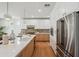 Modern kitchen with white cabinets, stainless steel appliances, and an island with quartz countertop at 5537 E Earll Dr, Phoenix, AZ 85018