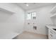 Clean laundry room featuring utility connections, storage shelves, and a convenient folding counter at 5537 E Earll Dr, Phoenix, AZ 85018