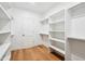 Spacious walk-in closet featuring custom shelving, wood floors, and a bright, neutral color palette at 5537 E Earll Dr, Phoenix, AZ 85018