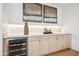 Modern wet bar featuring wood cabinets, quartz countertops and a wine fridge at 5537 E Earll Dr, Phoenix, AZ 85018