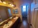 Bathroom with double sinks, large mirror, and tile floor at 5635 W Huntington Dr, Laveen, AZ 85339