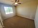 The bedroom includes a ceiling fan, a neutral color palette, and soft carpet at 5635 W Huntington Dr, Laveen, AZ 85339