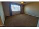 A sunlit bedroom with neutral walls, soft carpet, and a large window at 5635 W Huntington Dr, Laveen, AZ 85339