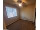 This bedroom offers a ceiling fan, a large window with natural light and soft carpet at 5635 W Huntington Dr, Laveen, AZ 85339