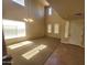 The open-plan living room with carpet flooring, ample natural light, and a chandelier at 5635 W Huntington Dr, Laveen, AZ 85339