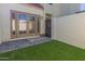 Outdoor patio and artificial turf in backyard, with patio doors and a privacy fence at 6004 N 79Th St, Scottsdale, AZ 85250