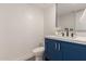 Stylish half bathroom with blue vanity, quartz countertop, and modern mirror at 6004 N 79Th St, Scottsdale, AZ 85250