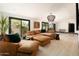 Spacious living room with large brown sectional, stylish lighting, and access to a private outdoor area at 6102 E Friess Dr, Scottsdale, AZ 85254