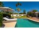 Relaxing pool area with lounge chairs and umbrella, set amidst palm trees and landscaped greenery at 6102 E Friess Dr, Scottsdale, AZ 85254
