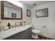 Charming powder room with wood-look floors, marble vanity top, and decorative accents at 6349 N 78Th St # 105, Scottsdale, AZ 85250
